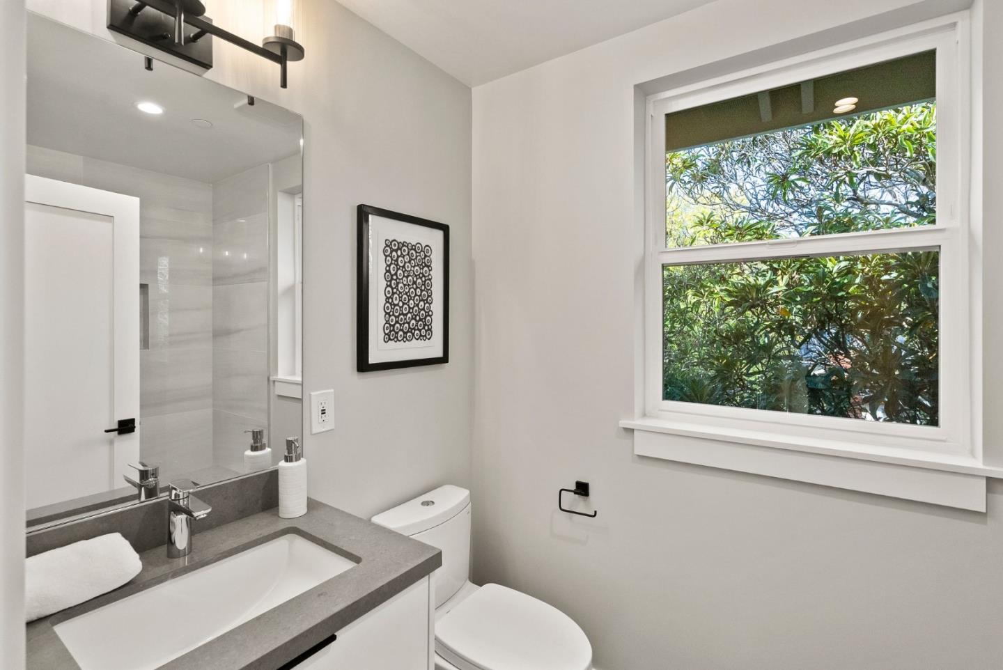 275 Willow Road Menlo Park, CA 94025 - Photo 32 of 40 a bathroom with a toilet a sink a mirror and a window
