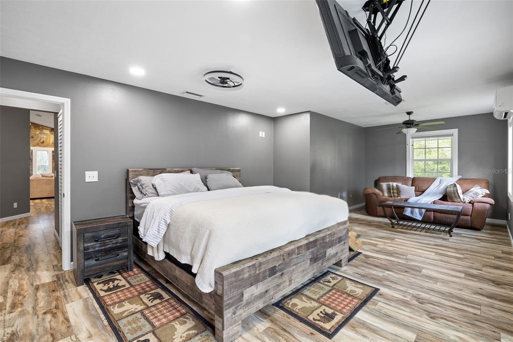 11311 Northeast 40th Street Road Silver Springs, FL 34488 - Photo 26 of 67 a spacious bedroom with a bed and a chandelier