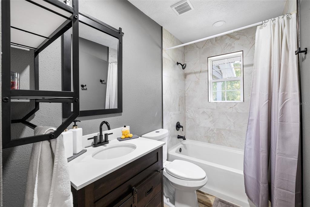 11311 Northeast 40th Street Road Silver Springs, FL 34488 - Photo 37 of 67 a bathroom with a sink toilet a mirror and bathtub