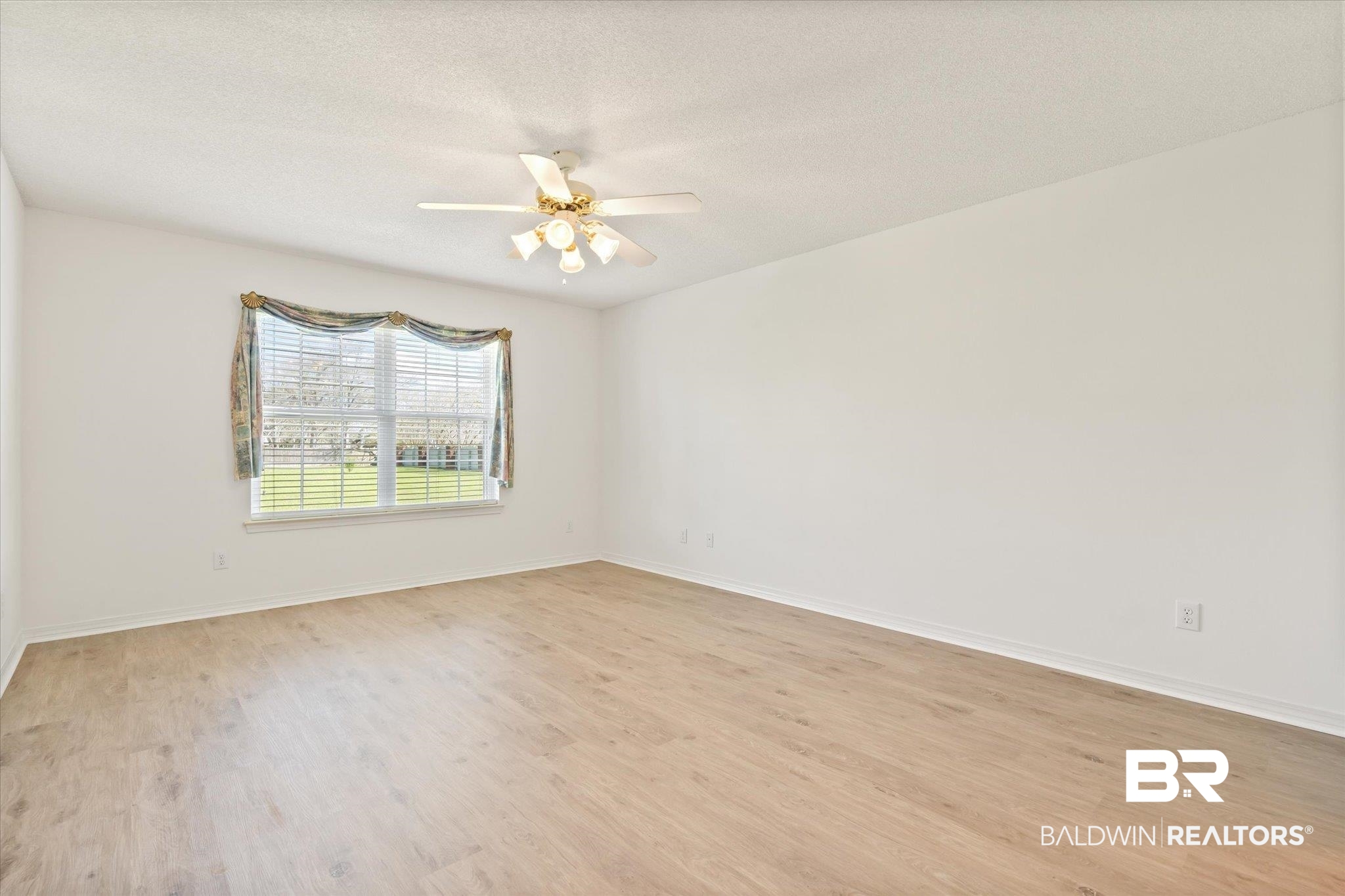 12520 Hunters Chase Foley, AL 36535 - Photo 23 of 32 Empty room featuring a textured ceiling, baseboards, light wood finished floors, and ceiling fan
