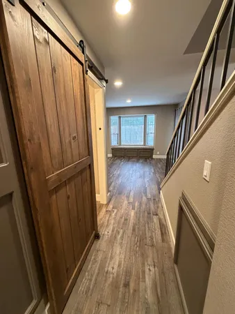 a view of a hallway with wooden floor and staircase
