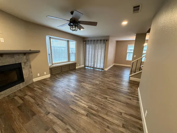 a view of an empty room with a fireplace and a window