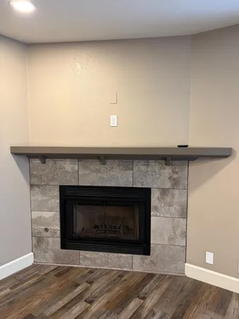 a fireplace with a clock on wooden floor