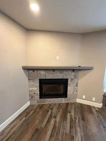 an empty room with wooden floor and a fireplace