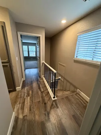 a view of a hallway with wooden floor and staircase
