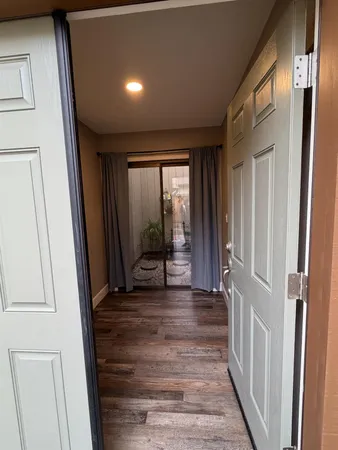 a view of a hallway with wooden floor and stairs