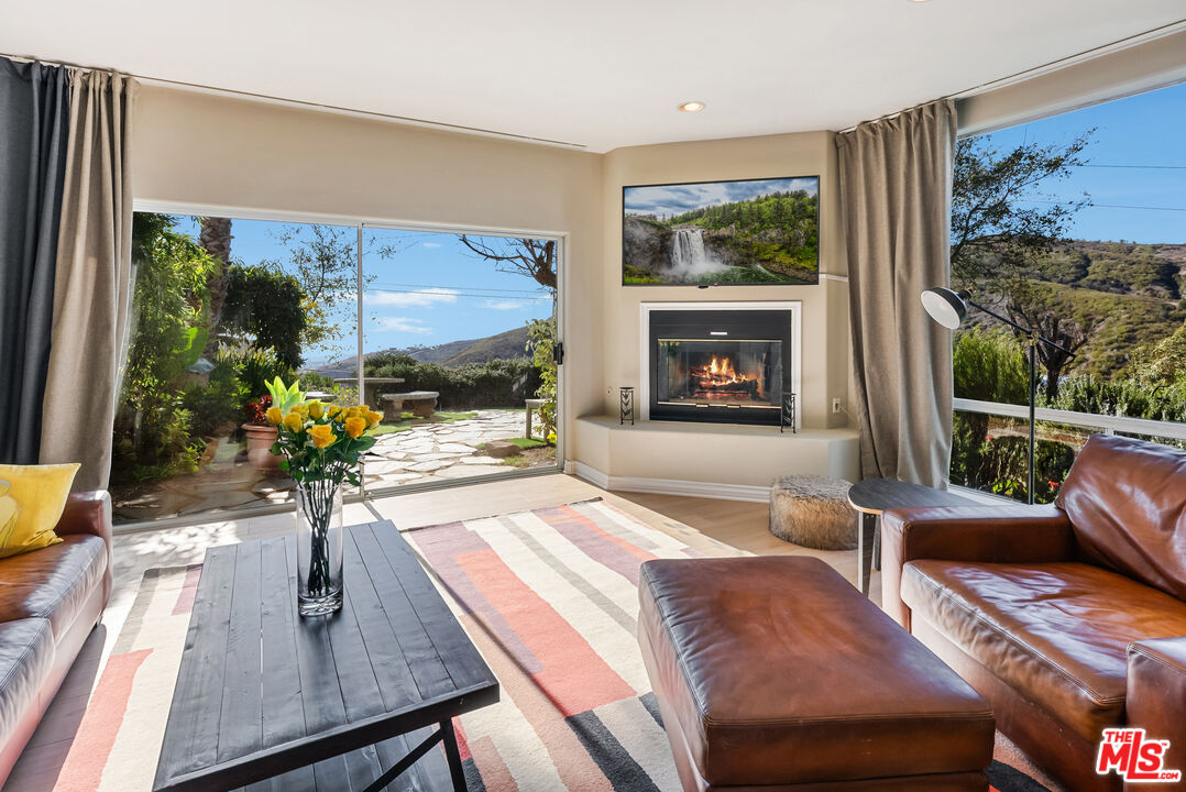 a living room with furniture fireplace and a large window