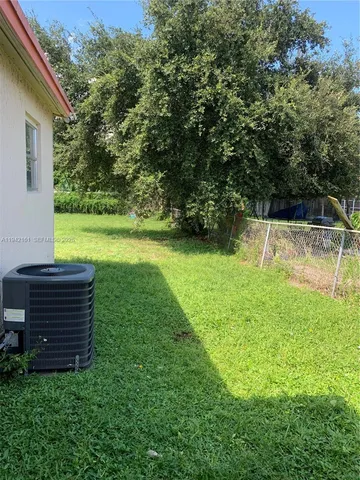 a view of a backyard with plants and a bench