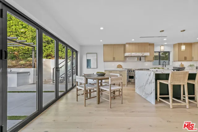 a large kitchen with lots of counter space a sink appliances and a large window