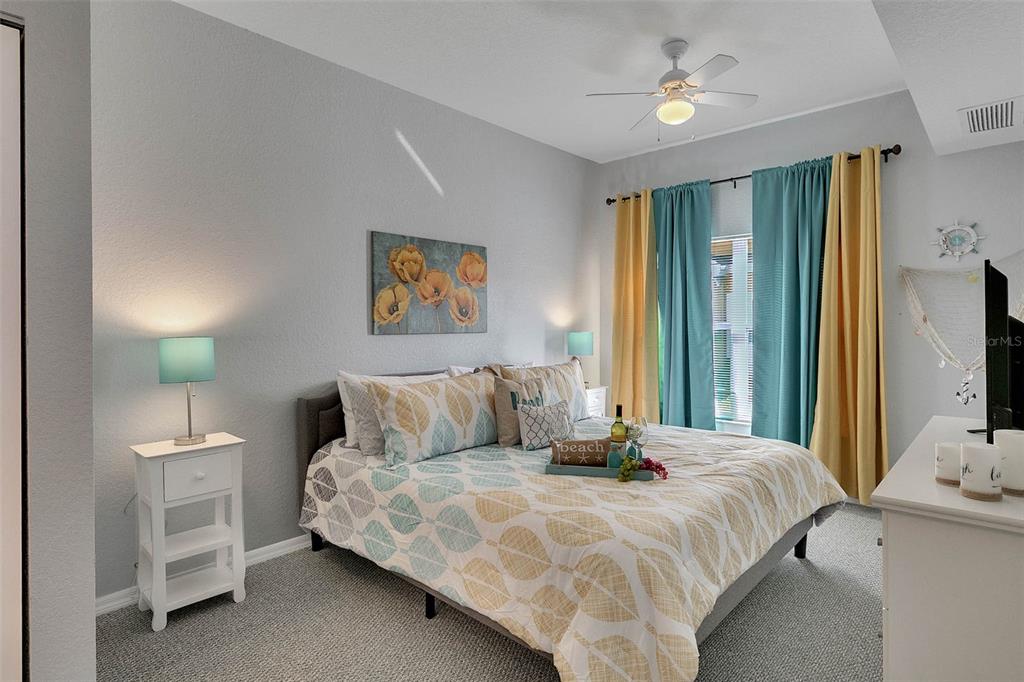 4561 Yellowgold Road East, Unit 102 Kissimmee, FL 34746 - Photo 4 of 12 a bedroom with a bed and a flat tv screen on dresser