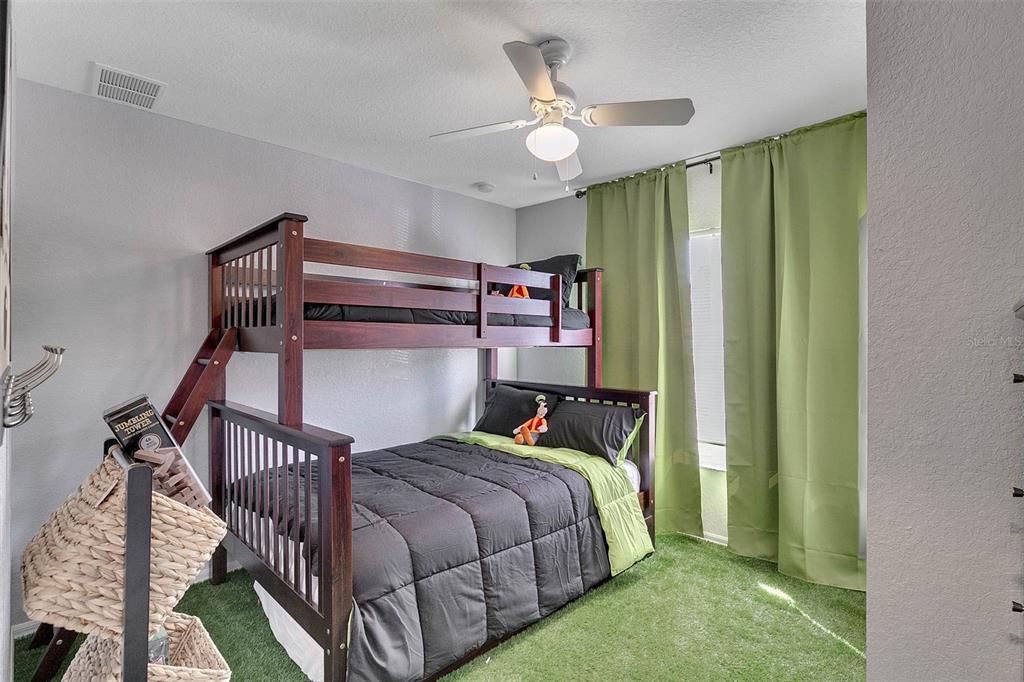 4561 Yellowgold Road East, Unit 102 Kissimmee, FL 34746 - Photo 6 of 12 a bedroom with a bed a chandelier and dresser
