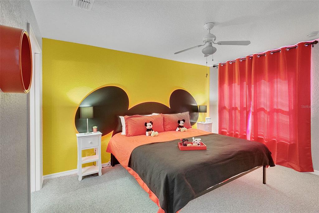 4561 Yellowgold Road East, Unit 102 Kissimmee, FL 34746 - Photo 8 of 12 a bedroom with a bed and a chandelier