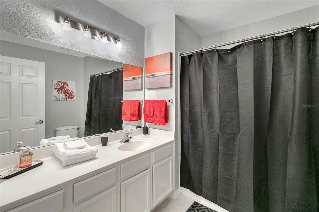 4561 Yellowgold Road East, Unit 102 Kissimmee, FL 34746 - Photo 9 of 12 a bathroom with a sink vanity and a mirror