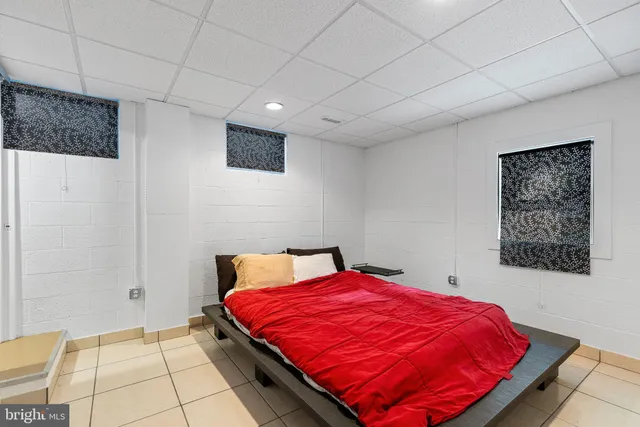 a bed sitting in a room next to a lamp