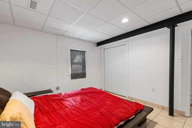 a bedroom with a bed and a painting on the wall