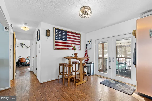 a view of a hallway with wooden floor and a livingroom