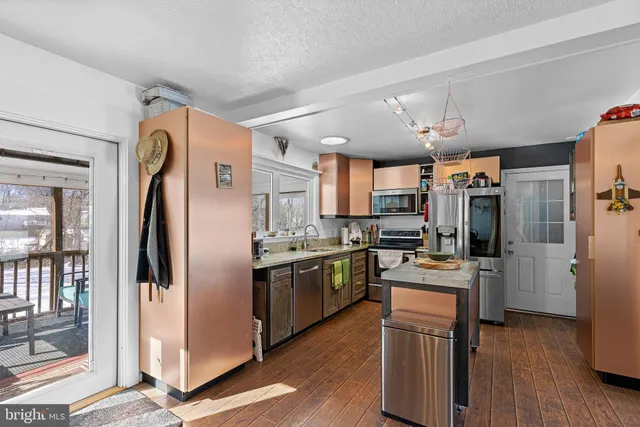 a kitchen with stainless steel appliances granite countertop a refrigerator and a stove