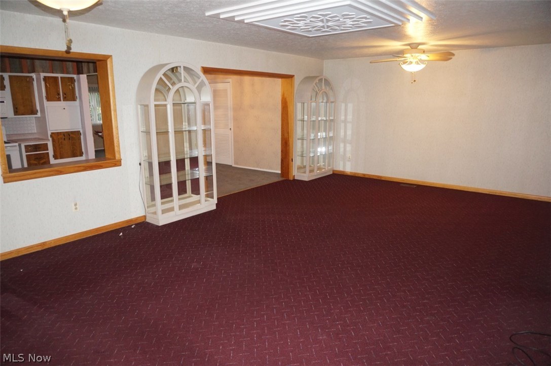 1087 Broadmoor Road Macedonia, OH 44056 - Photo 11 of 35 Fully carpeted family room with two ceiling fans leading back into the dining room. Sorry but the cabinets were picked up by family and no longer there. More room for your things!!