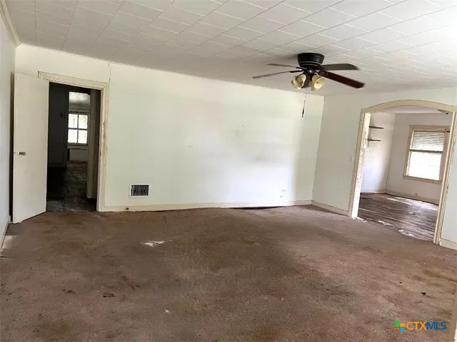 an empty room with a empty space and a ceiling fan