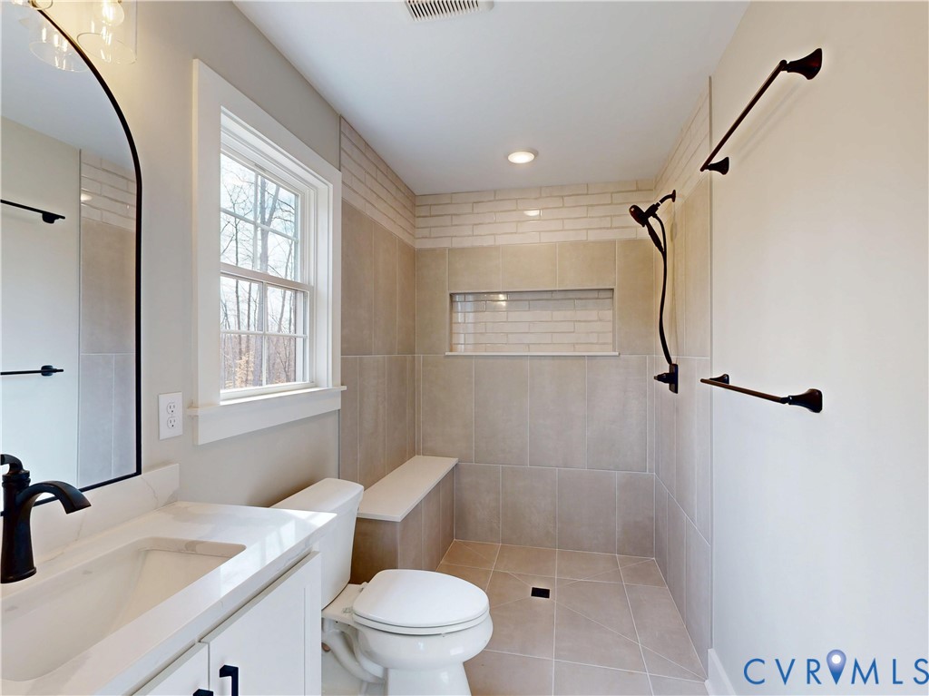 15085 Lebanon Road Spring Grove, VA 23881 - Photo 10 of 16 a bathroom with a granite countertop sink toilet a mirror and shower