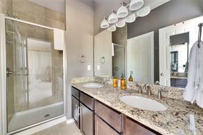 2947 Moss Street Austin, TX 78722 - Photo 12 of 15 Full bath featuring a stall shower, double vanity, and light tile patterned flooring