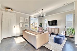 2947 Moss Street Austin, TX 78722 - Photo 3 of 15 Living area featuring concrete flooring and a chandelier