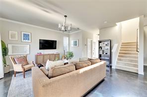2947 Moss Street Austin, TX 78722 - Photo 4 of 15 Living room with concrete flooring, stairs, and a chandelier