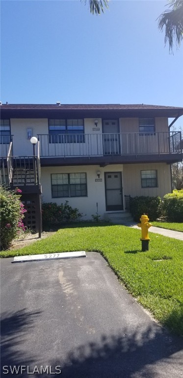 5277 Treetops Drive, Unit W204 Naples, FL 34113 - Photo 19 of 19 a front view of a house with a yard and a garage