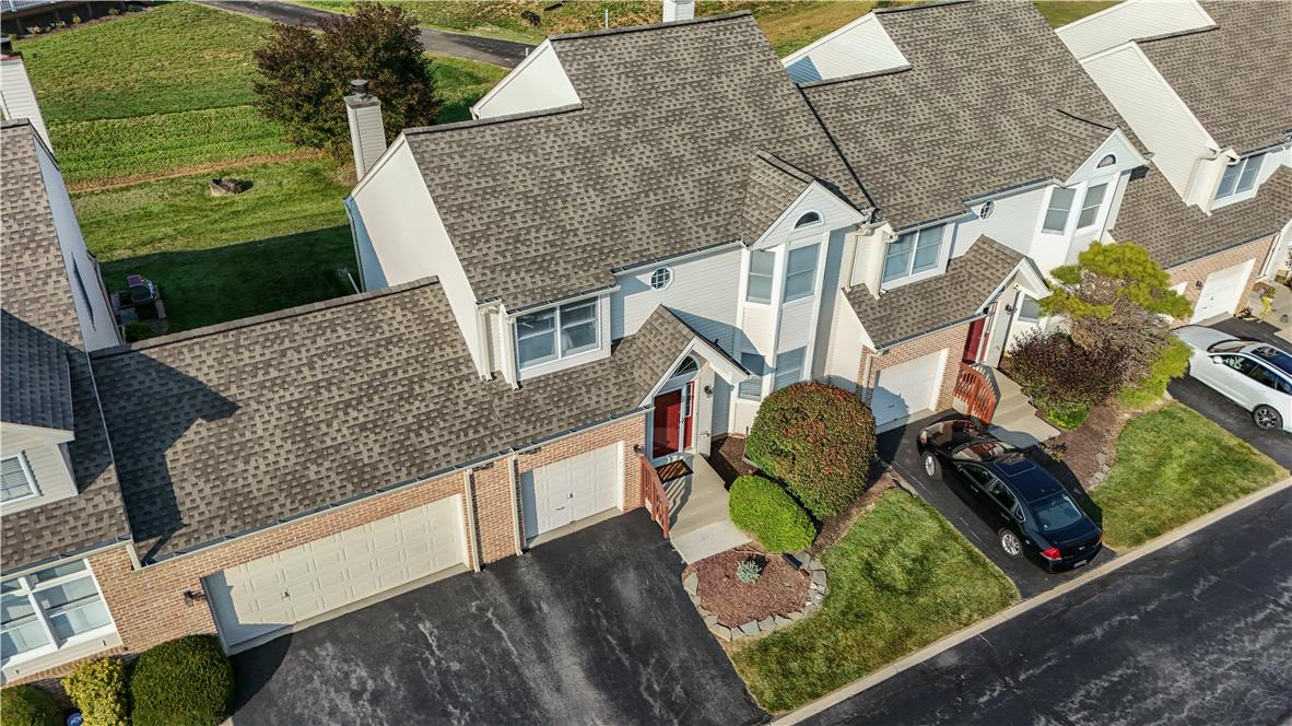 A high-angle view reveals classic multi-level architecture featuring gabled rooflines and attached garages.