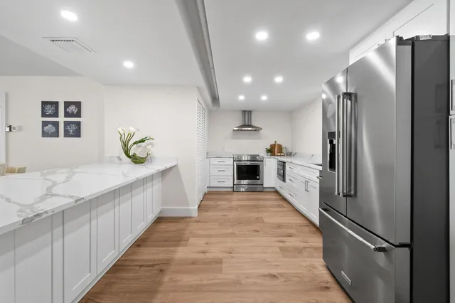 a kitchen with stainless steel appliances granite countertop a refrigerator and a sink