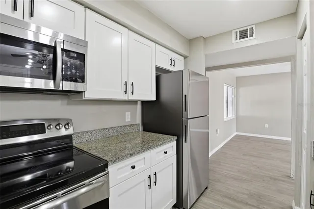 a kitchen with stainless steel appliances granite countertop a refrigerator and a stove