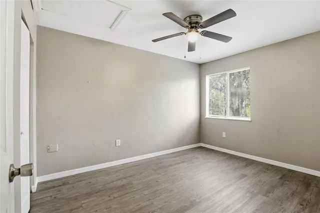 an empty room with windows and fan