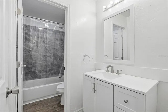 a bathroom with a bathtub shower sink vanity and mirror