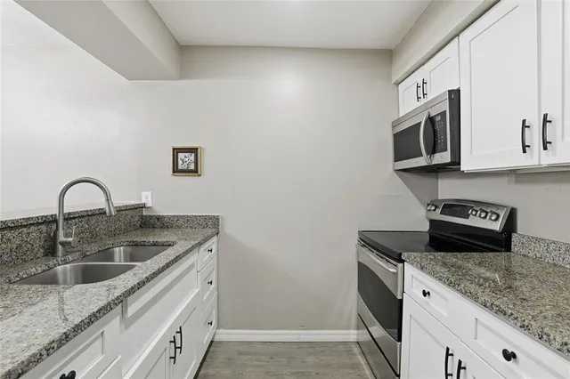 a kitchen with stainless steel appliances granite countertop a sink stove and microwave
