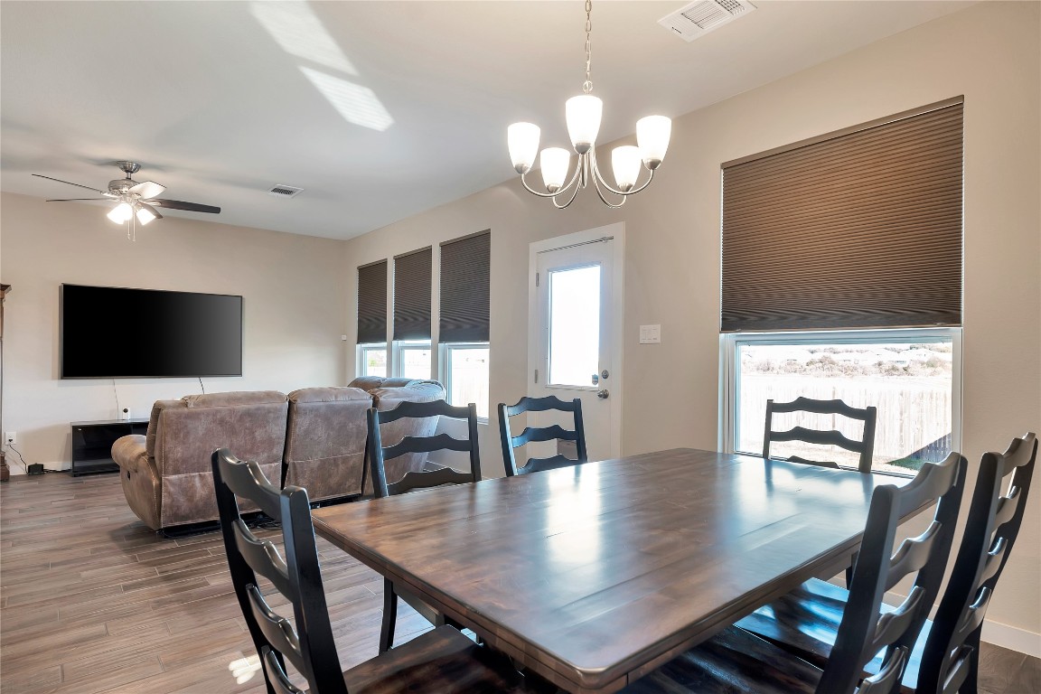 a view of a dining room with furniture a chandelier and wooden floor