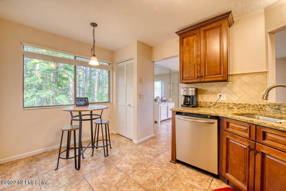 3801 Crown Point Road, Unit 3082 Jacksonville, FL 32257 - Photo 13 of 23 a kitchen with granite countertop sink stove and white cabinets
