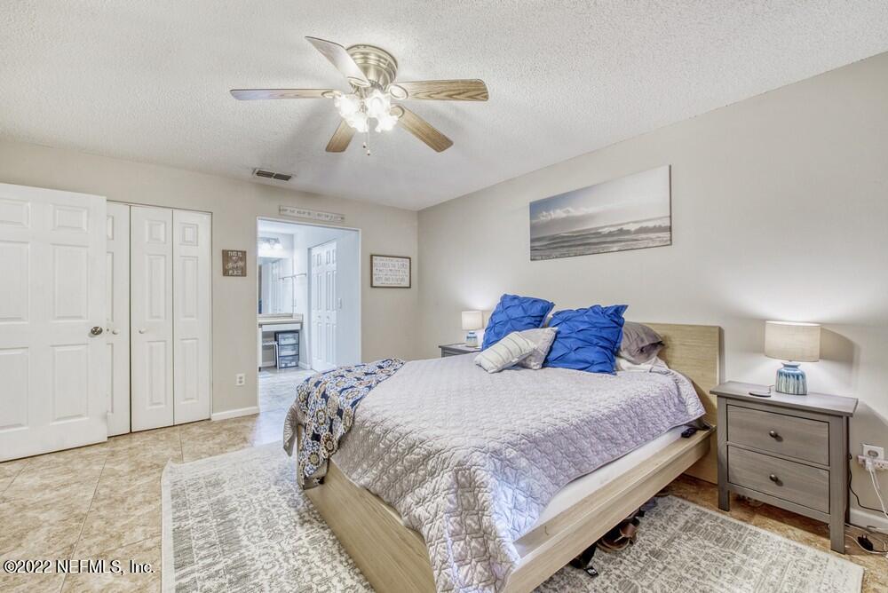 3801 Crown Point Road, Unit 3082 Jacksonville, FL 32257 - Photo 18 of 23 a bedroom with a large bed and a chandelier