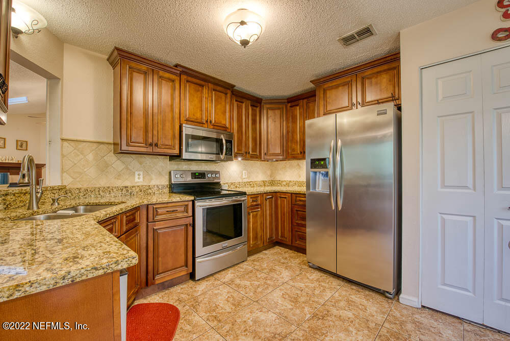 3801 Crown Point Road, Unit 3082 Jacksonville, FL 32257 - Photo 2 of 23 a kitchen with stainless steel appliances granite countertop a refrigerator a stove top oven a sink and dishwasher