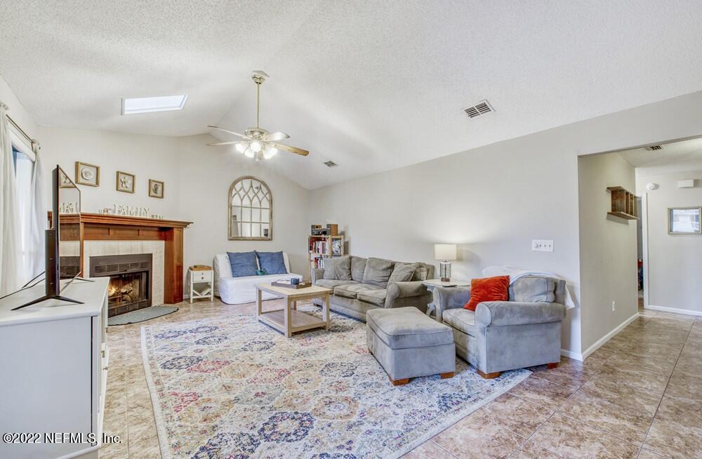 3801 Crown Point Road, Unit 3082 Jacksonville, FL 32257 - Photo 10 of 23 a living room with furniture a fireplace and a chandelier