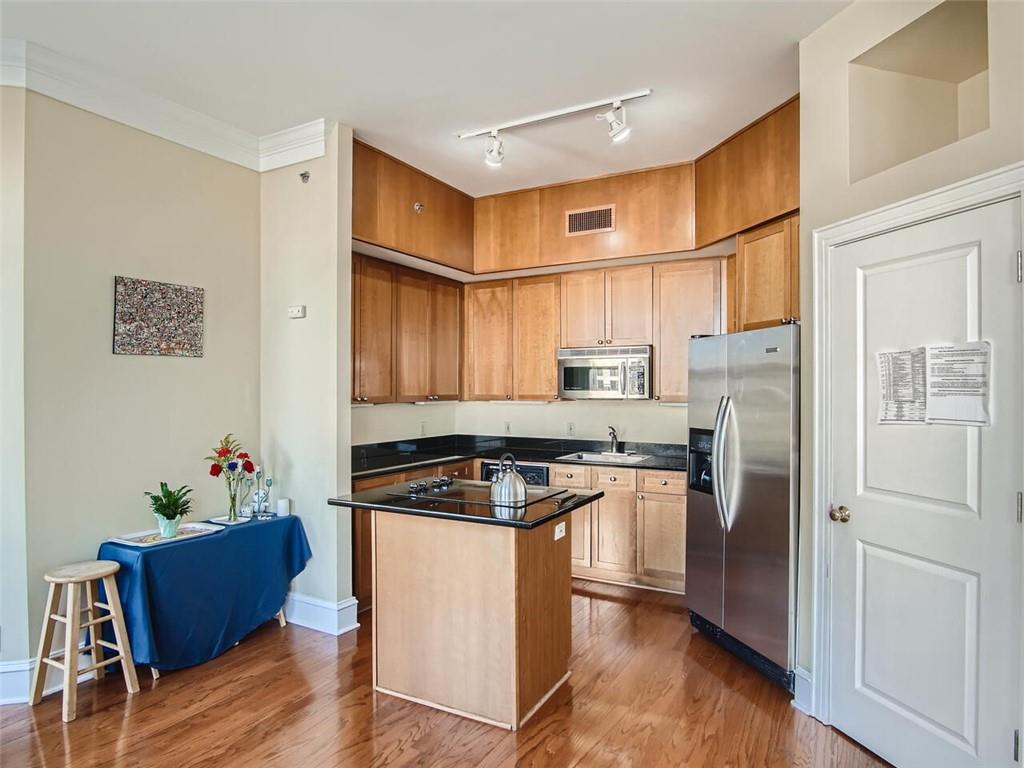 57 Forsyth Street Northwest, Unit 9C Atlanta, GA 30303 - Photo 3 of 11 a kitchen with stainless steel appliances granite countertop a stove a refrigerator and a refrigerator