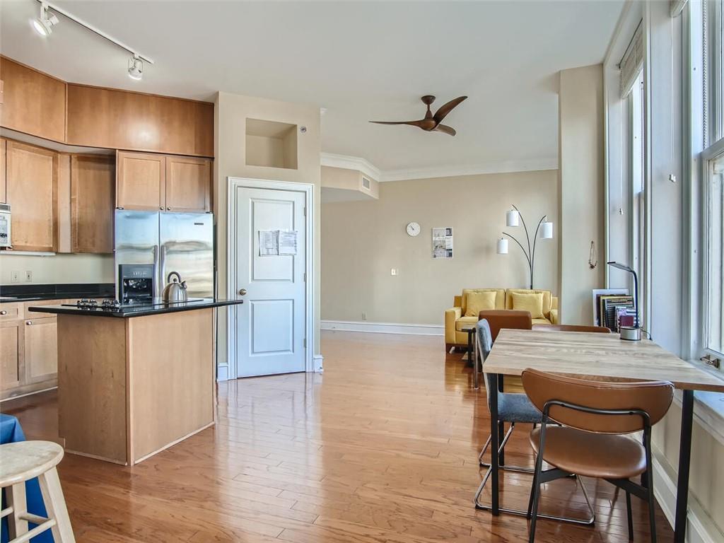 57 Forsyth Street Northwest, Unit 9C Atlanta, GA 30303 - Photo 7 of 11 a dining hall with stainless steel appliances granite countertop a refrigerator a stove a dining table and chairs with wooden floor