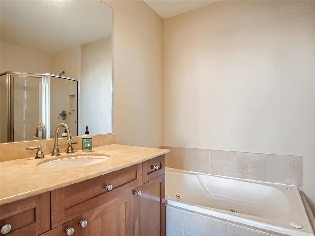 57 Forsyth Street Northwest, Unit 9C Atlanta, GA 30303 - Photo 9 of 11 a bathroom with a granite countertop sink mirror and a bathtub