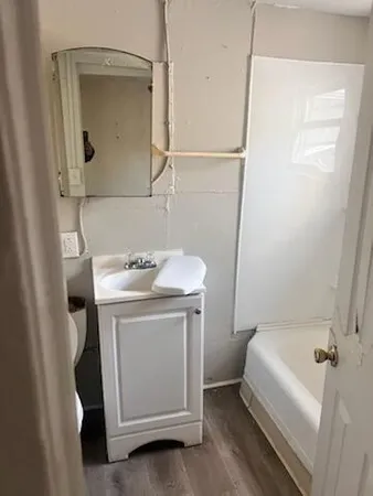 a bathroom with a sink a toilet and shower