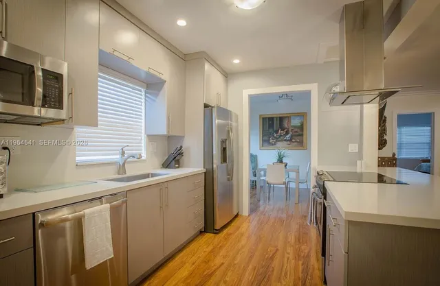 a kitchen with a sink and wooden floor