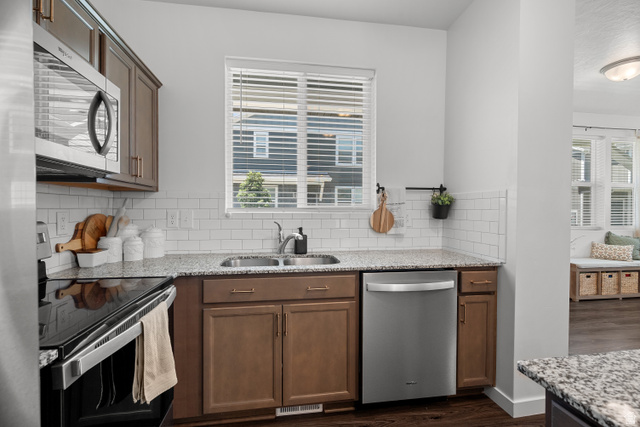 1708 North 1280th Street East Payson, UT 84651 - Photo 3 of 15 Kitchen featuring stainless steel appliances, wood-finish cabinetry, speckled countertops, and subway tile backsplash