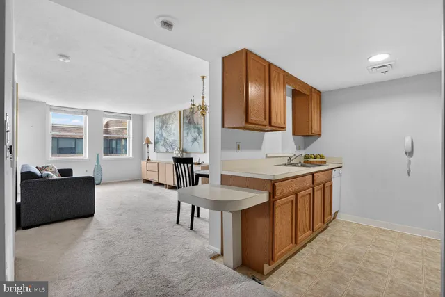 a living room with stainless steel appliances kitchen island granite countertop a table and chairs in it