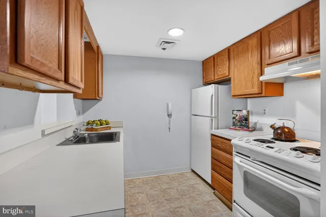a kitchen with stainless steel appliances a stove a refrigerator a sink and cabinets