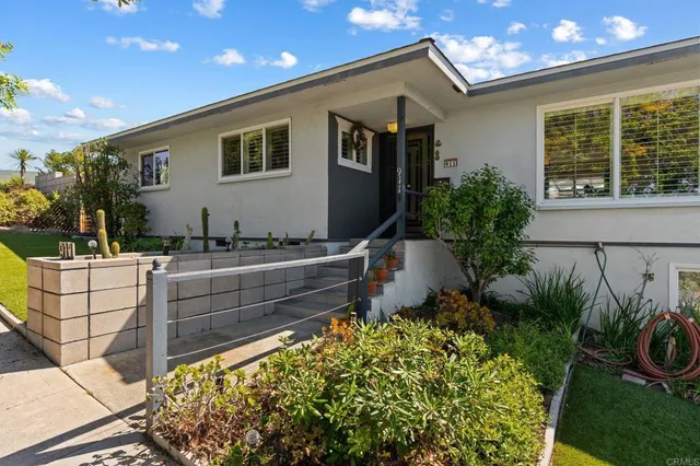 a front view of a house with plants
