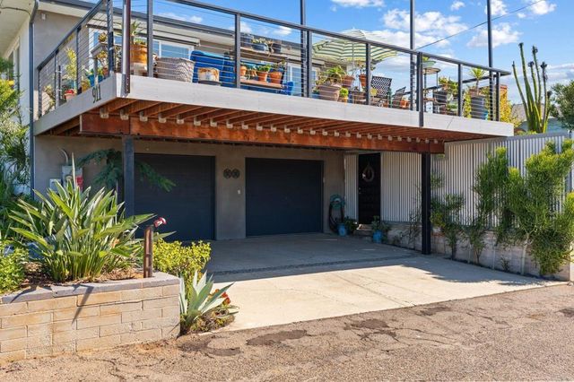 a view of a house with a yard and potted plants