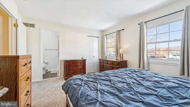 a bedroom with a bed and a dresser next to a window